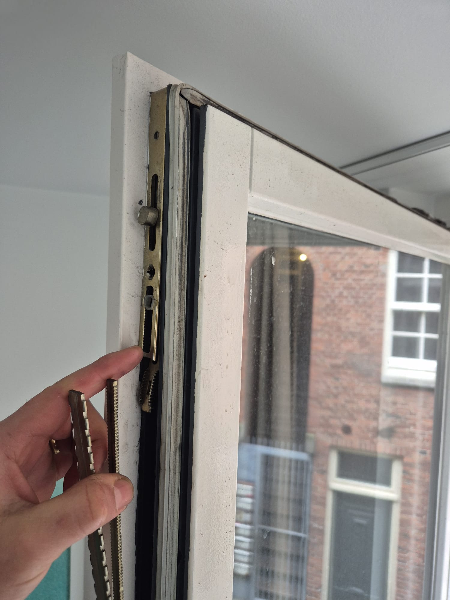 Twee tandstrips van een meerpuntssluiting naast het sluitpunt in een houten kozijn